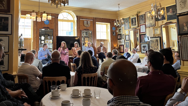 two speakers in front of a crowd in an auditorium