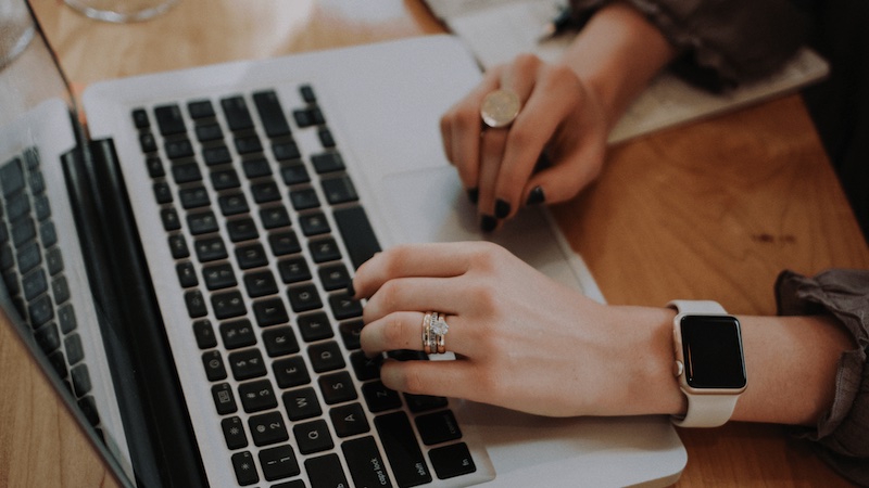 Close up of woman's hands typing on a laptop