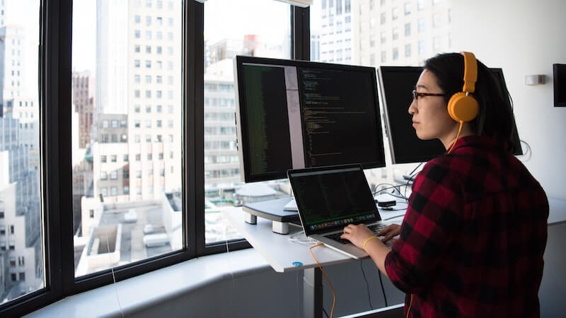 woman working on multiple monitors