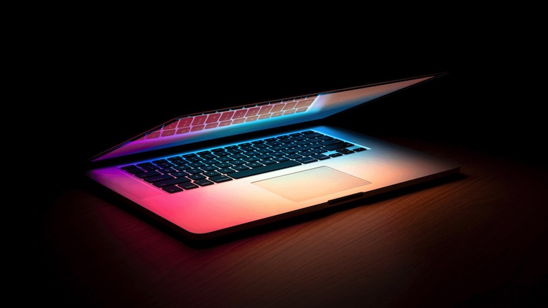 Half open laptop with the screen on, highlighting the keyboard