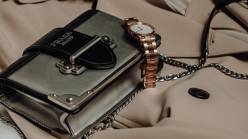 Handbag and watch laid down on a coat