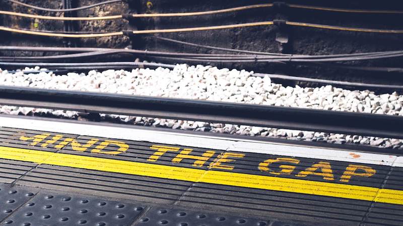 Mind the Gap sign at rail tracks